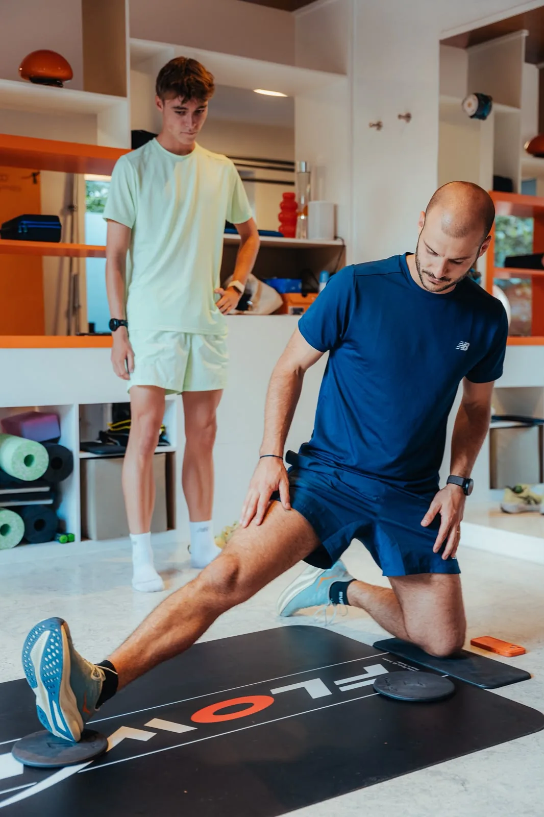 Kinésithérapeute en fente qui montre l'exercice à un sportif